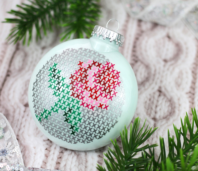 Cut craft vinyl with your Silhouette machine and layer it on a clear glass ornament to create a cross stitch design