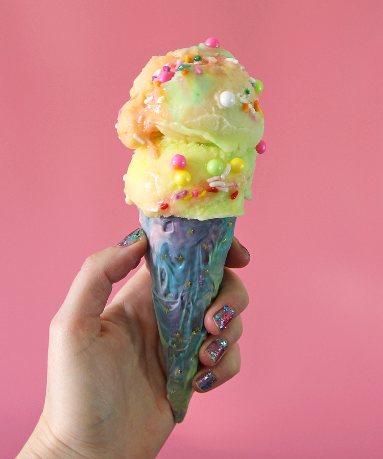 Colorful chocolate swirl ice cream cone with gold sprinkles